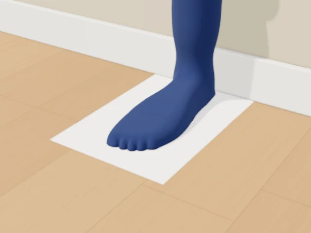 A foot in a dark sock standing on the sheet, heel against the wall, toes pointing along the paper.